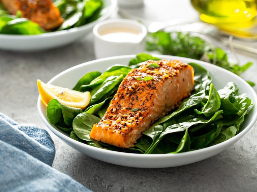 Za’atar-spiced salmon fillet served on a bed of fresh spinach with lemon wedge – a Mediterranean dish rich in omega-3s to support perimenopause brain fog.