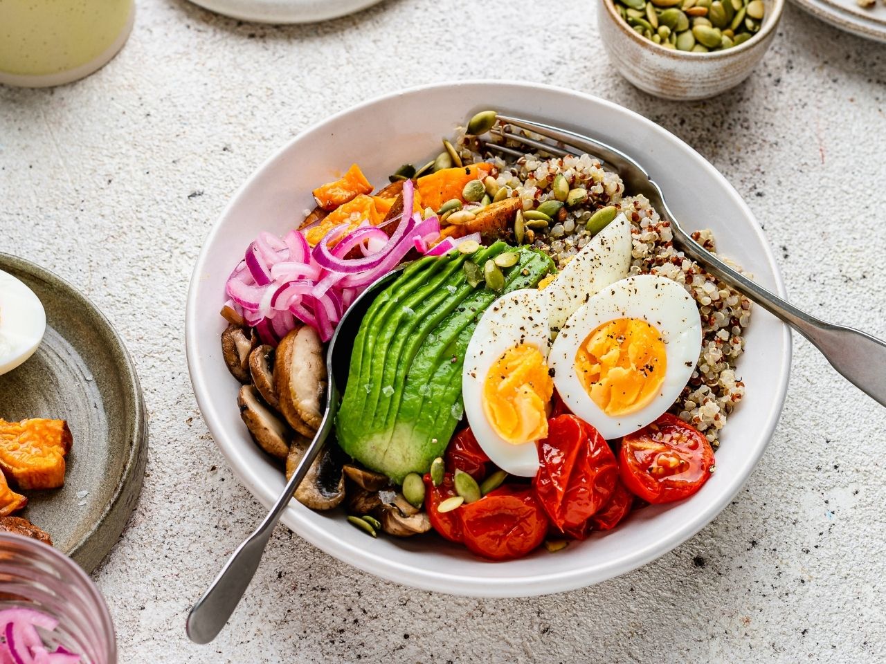 A colourful menopause abundance bowl with quinoa, eggs, avocado, mushrooms, sweet potato, and tomatoes – nutrient-dense support for perimenopause and menopause nutrition.
