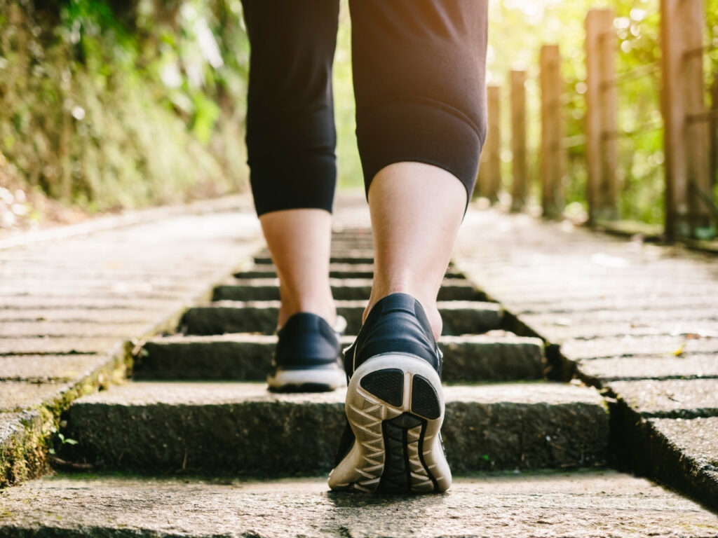 Close-up of a woman walking up outdoor steps, promoting weight-bearing exercise for bone health during perimenopause and menopause.